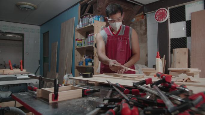 技术木匠，拿着木材零件木材材料锯一张木板