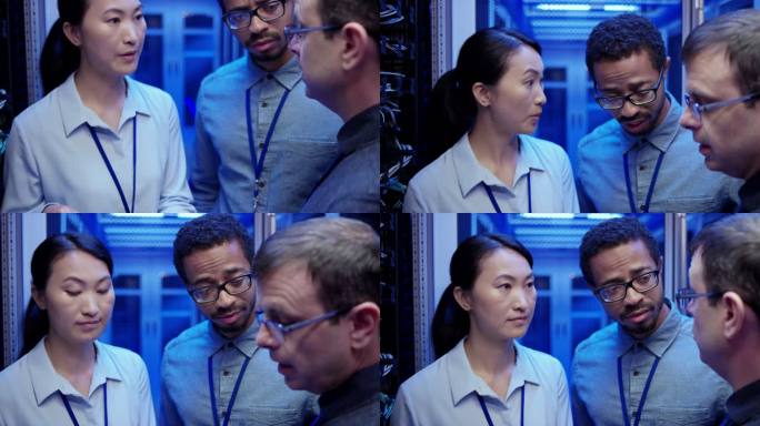 两名男网络工程师和一名女网络工程师站在服务器机房里讨论一些事情