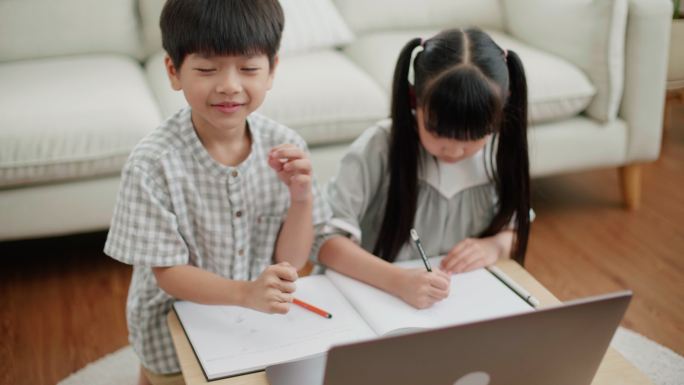亚洲儿童用笔记本电脑和绘图