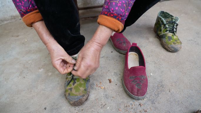 农村妇女换鞋系鞋带准备下地干活