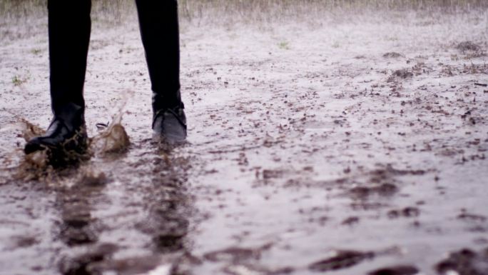 骑师靴特写镜头大雨中行走泥泞