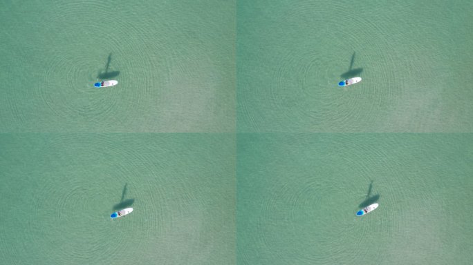 鸟瞰亚洲男子夏日在绿松石色热带清澈的海水中锻炼仰卧。