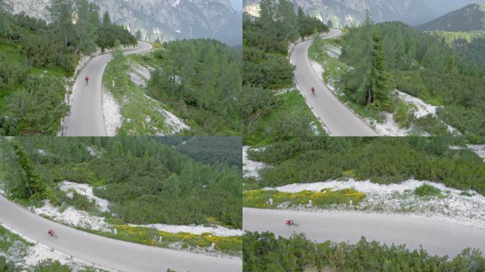 空中女性公路自行车手在森林环绕的山路上骑行