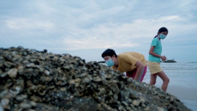 快乐的亚洲男孩在海边的岩石上寻找平静，生活方式理念。