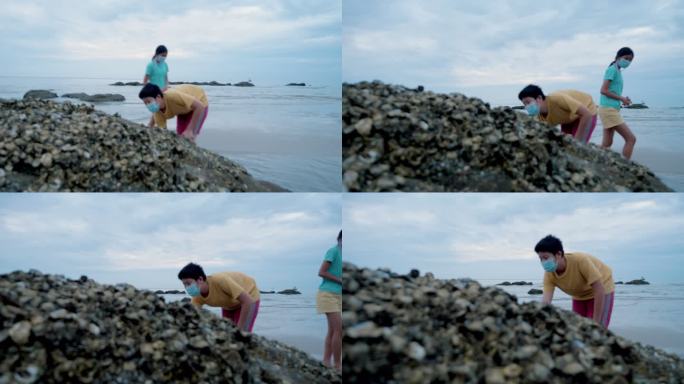 快乐的亚洲男孩在海边的岩石上寻找平静，生活方式理念。