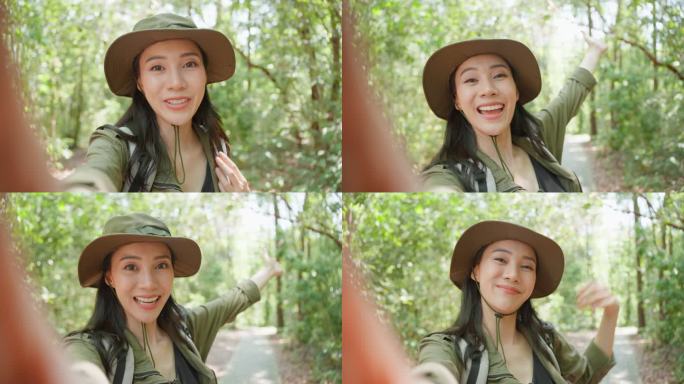 亚洲美女背包客vlogger独自在森林里旅行。迷人的女孩旅行者在假期旅行中使用手机记录视频日志，在自