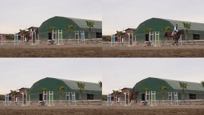 慢动作两名马术跳高运动员准备在跳跃区比赛。