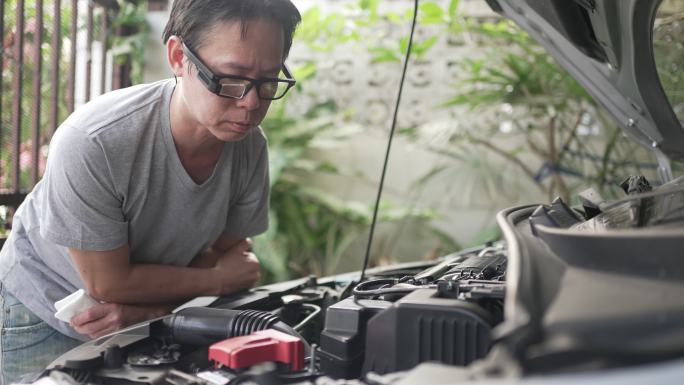 一个人用智能眼镜检查汽车的引擎。