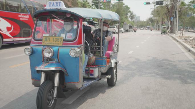 曼谷概念轮椅旅游地标。亚洲男性游客乘坐传统的公共推土车旅行。