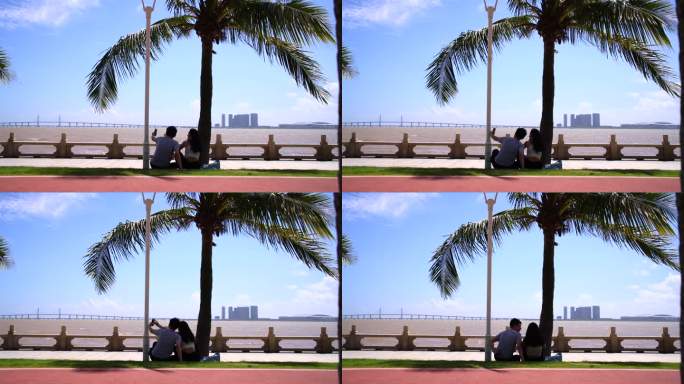 情侣在用手机拍照珠海情侣路海边沙滩