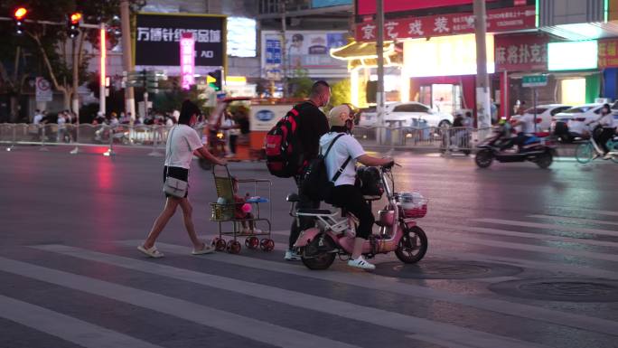 手推婴儿车过马路打工人城市打拼