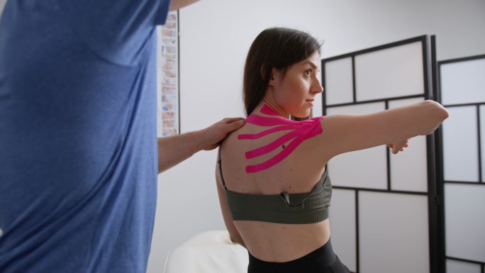 SLO MO物理治疗师向女性患者展示伸展运动