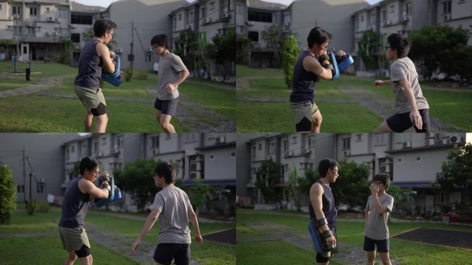 亚裔中国父子在户外后院训练跆拳道。