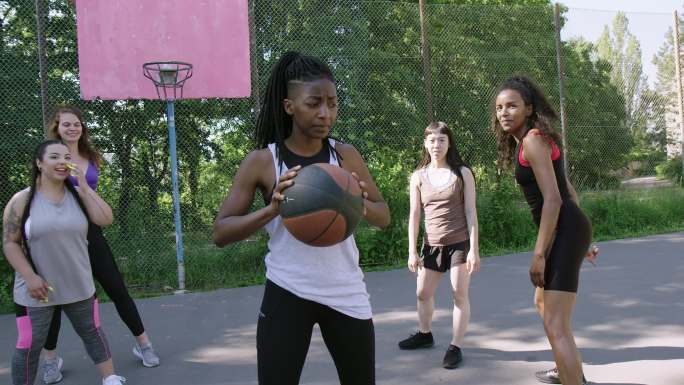 在运动场上打篮球的女性