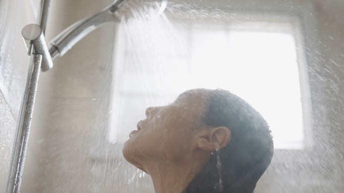 亚洲女人正在浴室洗头发和身体，慢动作