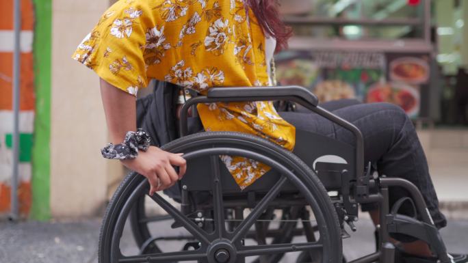 路边使用轮椅的亚洲印度残疾美女侧视图