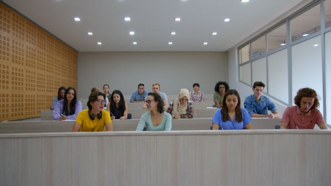 一群大学生在课堂上举手向老师提问