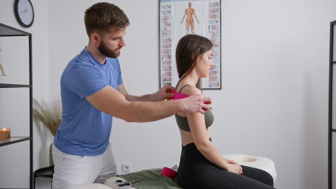 SLO MO物理治疗师为年轻女性的肩膀准备运动治疗磁带