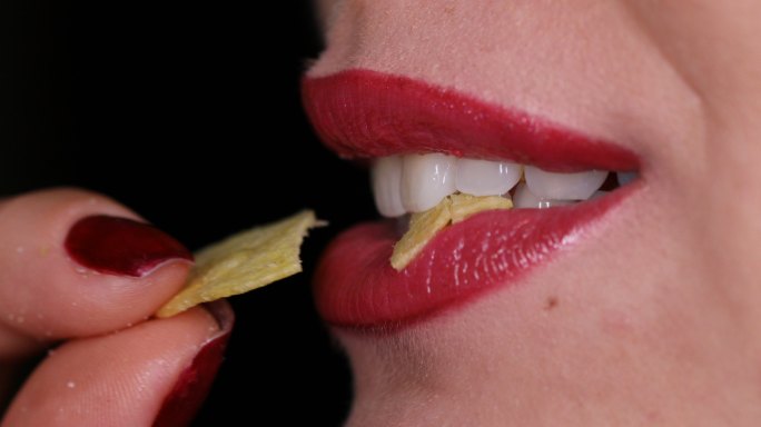 女性牙齿咬薯片吃零食
