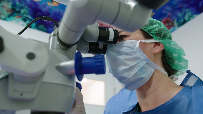 青光眼专家使用显微镜进行眼部手术