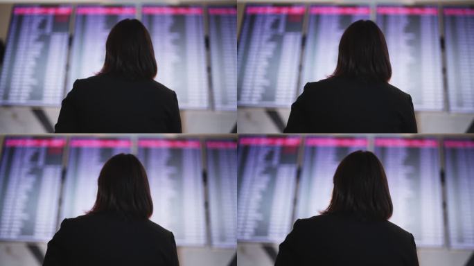 女商人在机场检查监视器屏幕上的航班信息。商务旅行