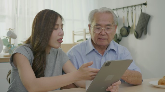 亚洲妇女帮助老人服药。