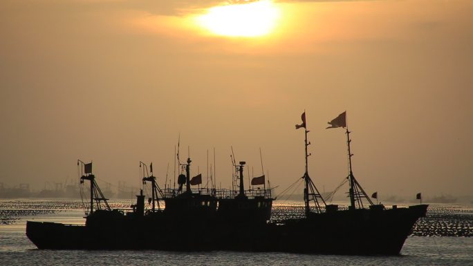 清晨日出时海面上的渔船