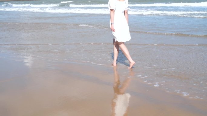 美女一个人走在海边散步沙滩海水脚步行漫步