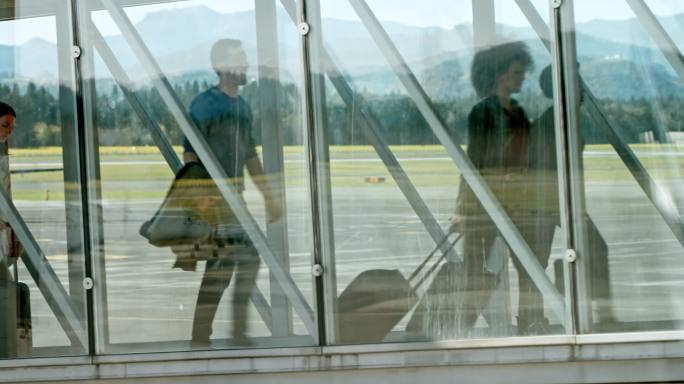 乘客在玻璃喷射桥上离开飞机