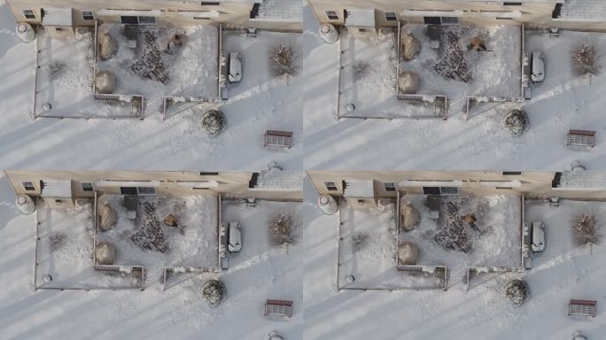 一位成年男子在冬季降雪后用铲子清理走廊上的积雪。无人机视频正上方的鸟瞰图。