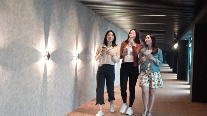 周末，亚裔中国女性朋友在走廊上看电影时边吃边聊
