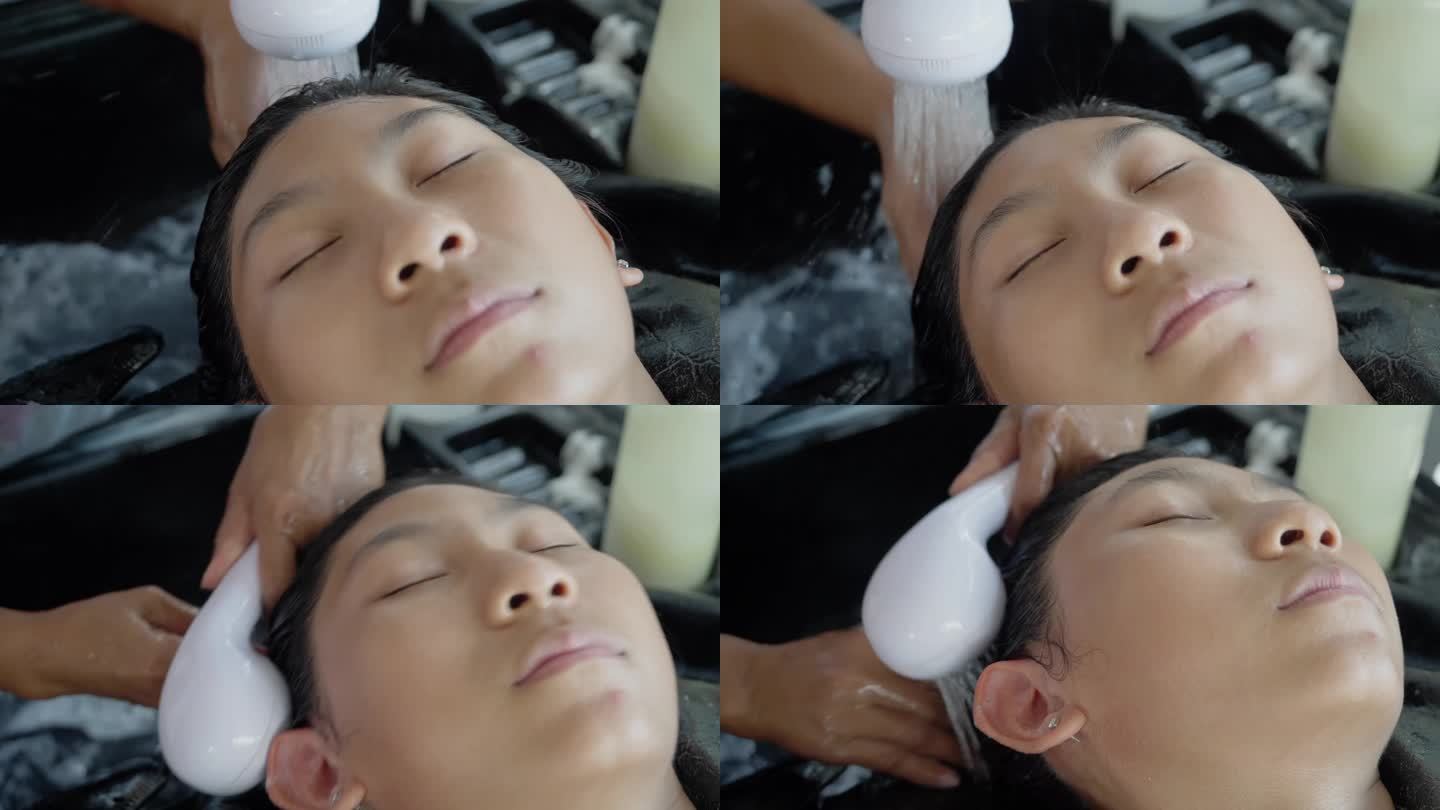 一位亚洲女孩躺在洗发水椅上，闭上眼睛，母亲在洗头，这是她的生活方式理念。