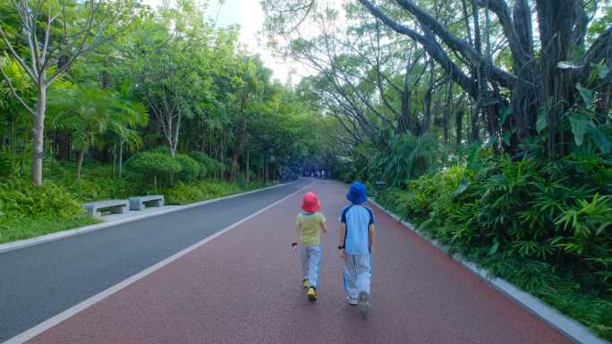 小朋友小学生走在林荫大道上