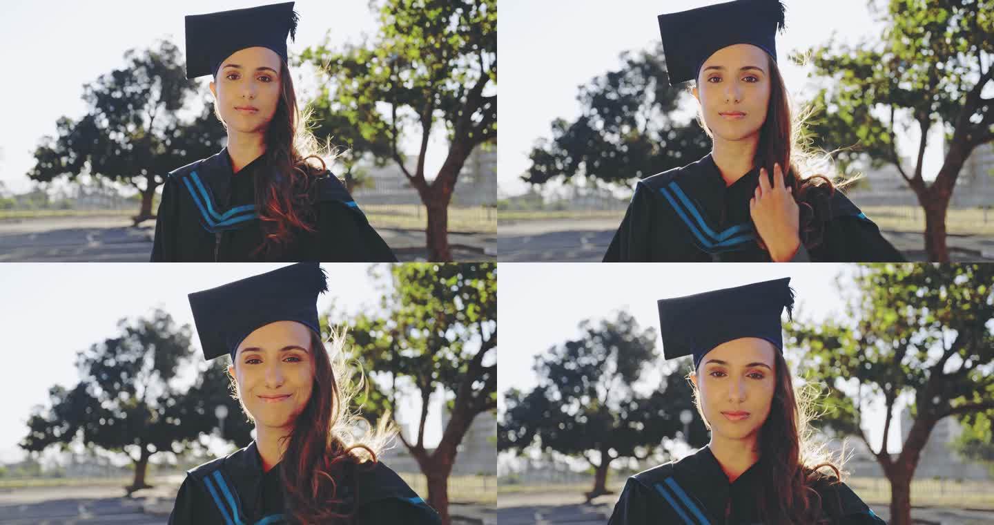 一个年轻的女学生在毕业那天站在大学校园外，看起来很开心。毕业生微笑着准备在校园典礼上接受毕业证书