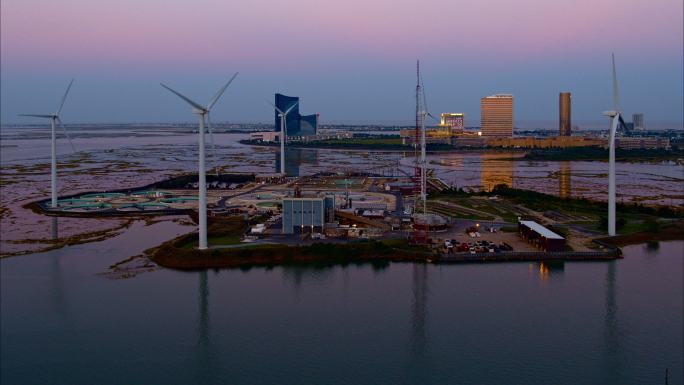 可持续能源用于环境保护。美国新泽西州大西洋城前的一座污水处理厂，由风力涡轮机和太阳能电池板提供动力。