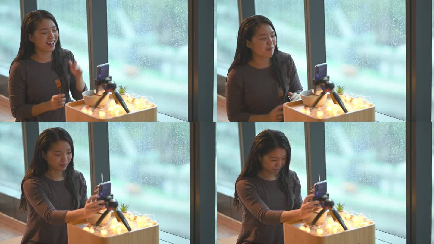 一位亚洲华裔少女雨天在房间里用智能手机吃苹果，脸上挂着微笑