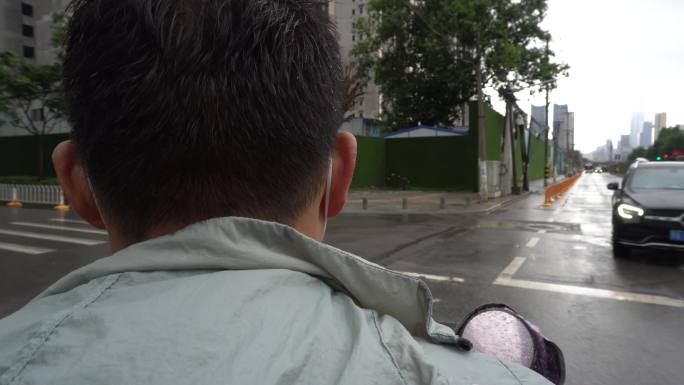 电动车雨天城市社区街道骑行后座视角
