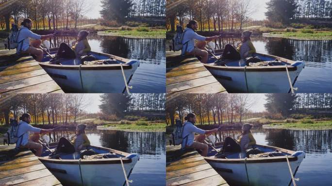 年轻夫妇在阳光明媚的秋湖划船钓鱼放松