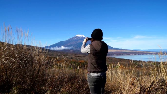 美丽的女人在富士山拍照。