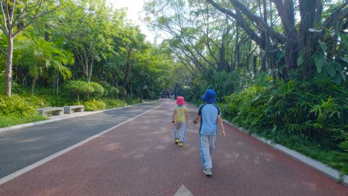 小朋友小学生走在林荫大道上