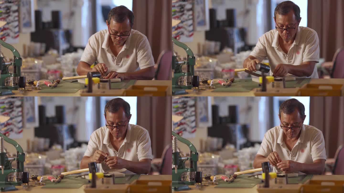 一位亚裔中国高级男子在他的工作室里制作手工皮革表带