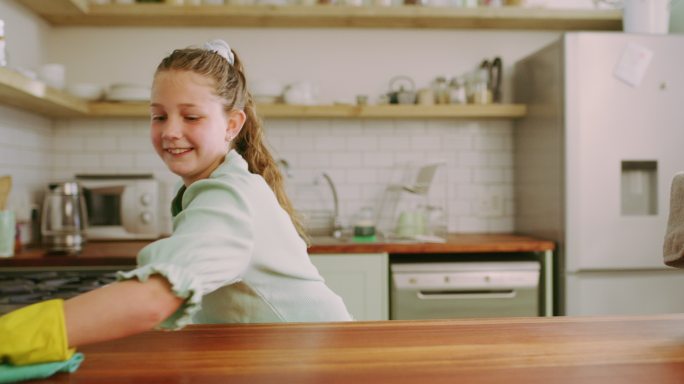 一个可爱的小女孩在家打扫厨房柜台的4k视频片段