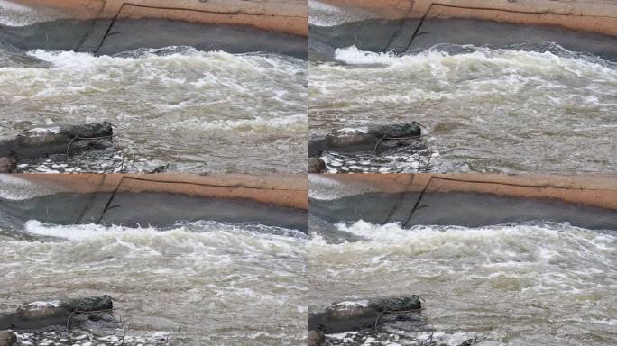 通过运河中的混凝土屏障看到的剧烈湍流。