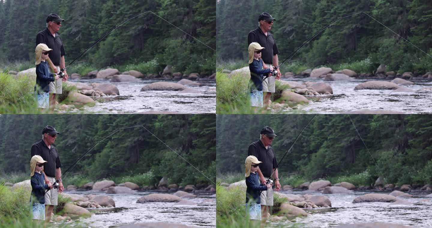 可爱的红头发男孩和祖父在魁北克河里钓鱼