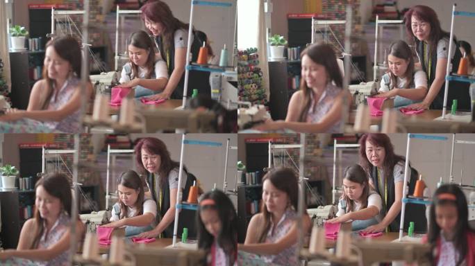 在工作室里，亚裔中国成年女裁缝用缝纫机教她的缝纫班学生缝纫技巧