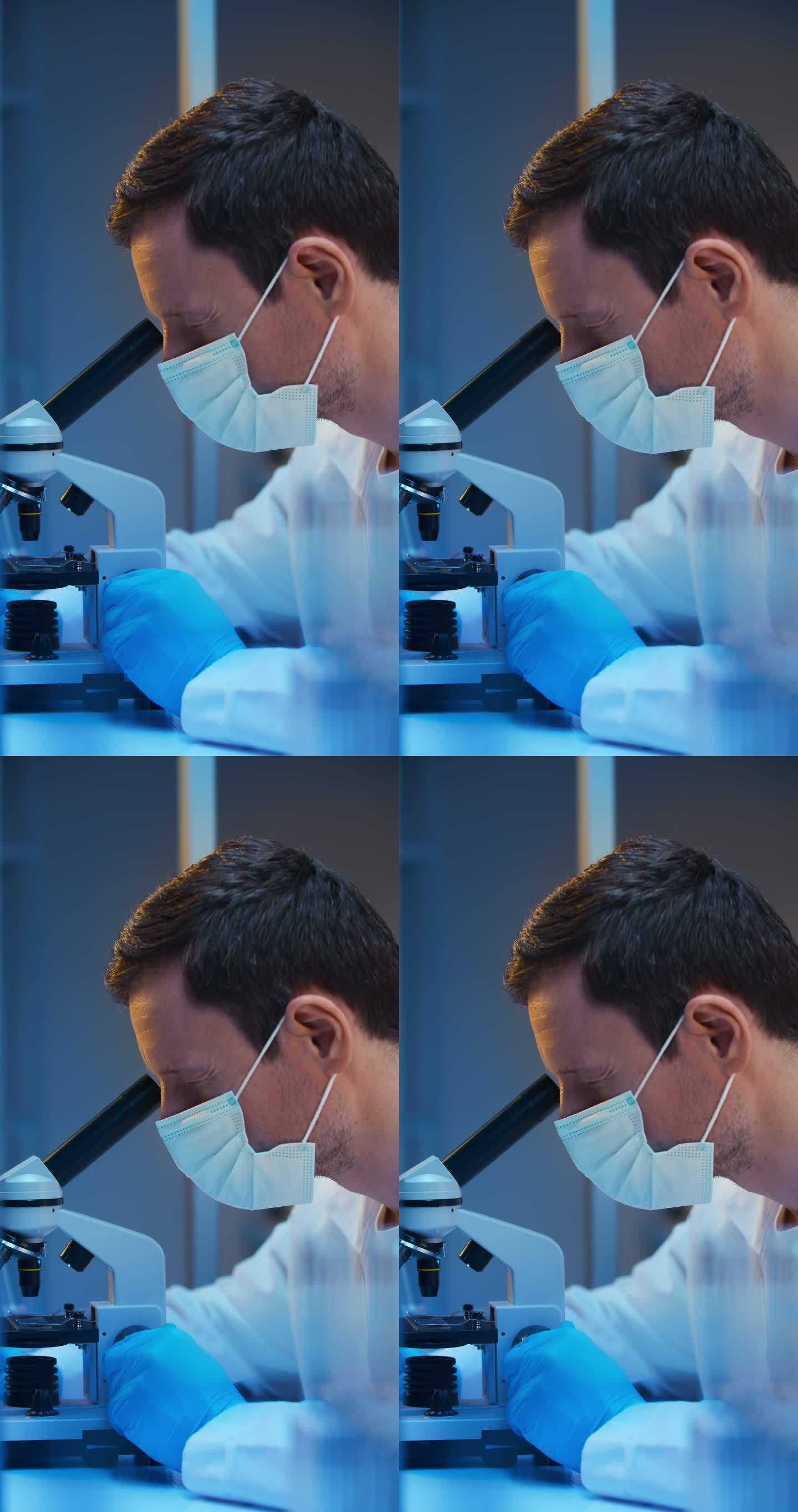一位严肃的白人化学家穿着实验服，戴着防护面罩，在现代实验室里用显微镜工作，我们看到他的侧面