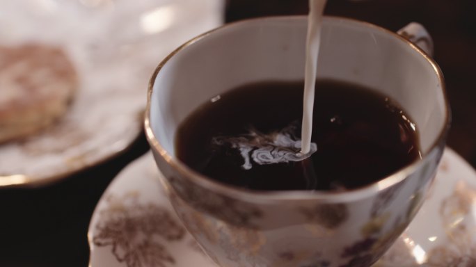 牛奶倒入装饰茶杯。