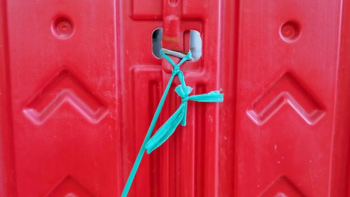 红绿对比一根绿色的绳子系在红色门上