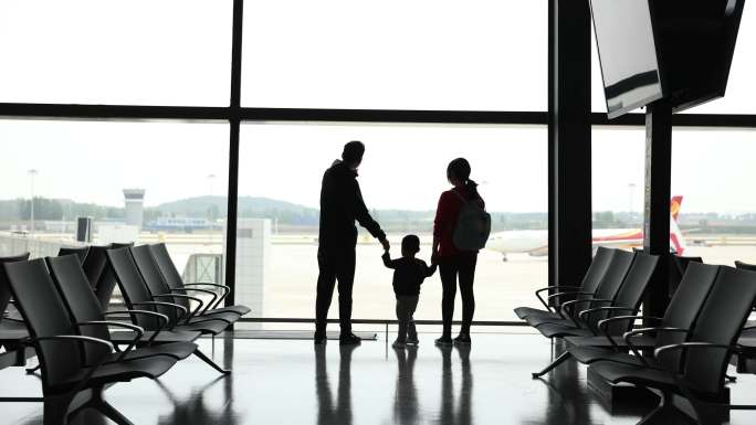 登机前站在机场窗户附近的家人