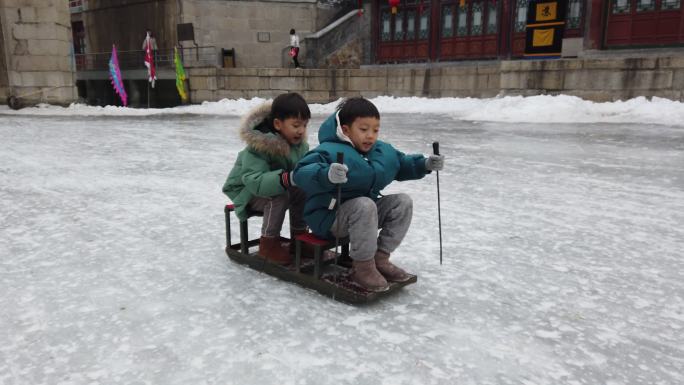 冬天，湖边的孩子们在北京颐和园结冰，享受雪橇、滑冰、冰上自行车的乐趣